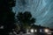 5k Timelapse. Dramatic Twilight Sky Spin Trails Of Stars On Night Sky Background. Stars And Meteoric Track Trails Rotate