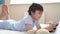 6-7 year old boy playing with dog toy and watching cartoon on tablet,Happy child lying in bed playing game in the morning, Cute Ki