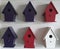 6 Bird boxes in different colors hang on white background