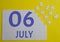 6 july calendar date on a white puzzle with separate details. Puzzle on a yellow background with a blue inscription