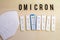 6 positive corona rapid tests lie next to a medical face mask and above them is the word Omicron
