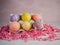 6 String Decorated Easter Eggs in a White Ceramic Holder Sitting on a Bed of Pink Paper Shreds