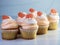 6 vanilla cupcakes with orange swirled frosting and an orange gum drop on top.  Festive, delicious, dessert for a celebration