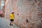 a 6-year blond boy near a old brick