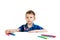 A 6 year old boy in a blue shirt paints with pencils on a white background isolate