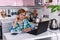 A 65-year-old woman works at home online by laptop and talks via phone because of the corona virus pandemic, more
