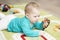 7-month child examines himself in a mirror lying on carpet. Baby boy girl playing with mirror. Portrait Kid Soft Focus