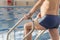 A 70-year-old pensioner is resting, swimming, recovering in the pool with clear and blue water in the hotel