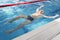 A 70-year-old pensioner is resting, swimming, recovering in the pool with clear and blue water in the hotel