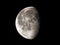 76 percent waning lunar moon in black night sky