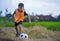 8 or 9 years old happy and excited kid playing football outdoors in garden wearing training vest running and kicking soccer ball