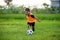 8 or 9 years old happy and excited kid playing football outdoors in garden wearing training vest running and kicking soccer ball