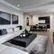 8 A contemporary, minimalist living room with a mix of white and black finishes, a low-profile sectional sofa, and a large, abst