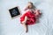 8 Eight months old baby girl laying down on white background with letter board and teddy bear. Flat lay composition.