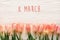 8 march text on pink tulips on white rustic wooden background. g