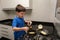 8 year old child putting a spoon of cocoa powder in condensed milk to make brigadeiro