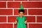 8 year old Latino boy with a Christmas tree hat and green shirt very happy and surprised by the arrival of December shows with his