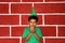 8 year old Latino boy with a Christmas tree hat and green shirt very happy and surprised by the arrival of December shows with his