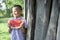 8 years old boy stands in the garden in the village and holds a large piece of watermelon, a small schoolboy smiles on a summer