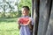 8 years old boy stands in the garden in the village and holds a large piece of watermelon, a small schoolboy smiles on a summer