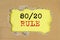 80 20 Rule concept inscription on yellow table through torn paper