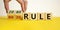 80 on 20 rule symbol. Male hand flips wooden cubes with words `80 on 20 rule`. Beautiful yellow table, white background, copy