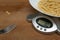 80 grams of pasta in a dish on a kitchen scale on wooden cutting board