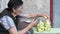 80s senior woman cut fresh zucchini into slices and put inside glass jars for homemade canning