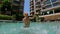 8x times slowmotion shot of a little boy splashing water in a pool