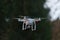 9 - Drone quadcopter with camera hovering in front of trees