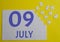 9 july calendar date on a white puzzle with separate details. Puzzle on a yellow background with a blue inscription