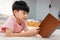 9-year-old Asian boy sitting and reading a book With pleasure, he readily reviewed the things he had learned each day in his bed