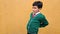 9-year-old dark-skinned boy in school uniform suffers from back and neck pain from carrying a heavy backpack has muscle strain