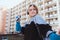 90s aesthetic. Outdoor shot over block of flats. Portrait of cheerful and positive young caucasian girl listening to