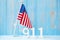 911 text and United States of America flag on wooden table background. Patriot Day, September, memorial and Never Forget concept