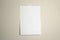 A4 white sheet of paper hanging on a wall glued with a piece of paper tape on a light background