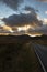 A4086 road, at sunset, heading towards the Llanberis Pass with mount Snowdon in the distance.