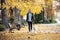 Aattractive young woman walking with her lovely golden retriever dog in the park in autumn