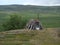 Abadoned Sami hut Goathi in green hills landscape of Abisko National Park. Goahti is Lappish traditional dwelling made from fabric