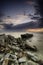 Abandon concrete structure along the shore over sunset background and dramatic cloud