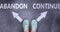 Abandon and continue as different choices in life - pictured as words Abandon, continue on a road to symbolize making decision and