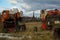 Abandoned agricultural machinery against the background of an ancient Orthodox church.