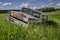 Abandoned antique blue sedan in tall grass on a hillside near Wymark, SK