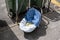 Abandoned baby carriage near public trash bin on sidewalk