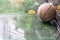 Abandoned basketball on a outdoor field with rain and puddles