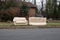 Abandoned beige couches on the grass by a curb in front of a house waiting to be removed by the garbage men