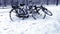 Abandoned bicycles covered in snow and covered with ice, stands at lamppost. Difficult winter weather conditions make cycling