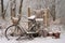 abandoned bike buried in snow near park bench