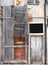 abandoned board up derelict house with padlocked door and decaying brick walls in italy