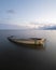 An abandoned boat, half-submerged in a lake, is a reminder of the power of nature and the beauty of decay